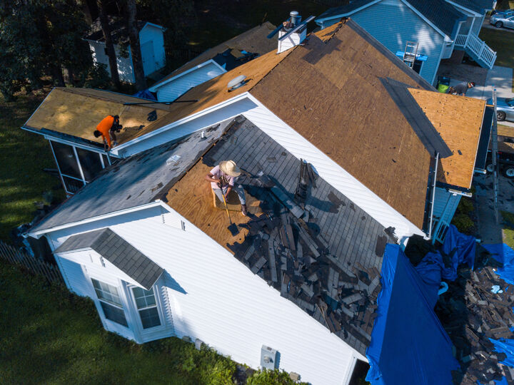 A Residential Roofing Crew In The Process Of Replacing A Roof Through Insurance Due To Storm Damage