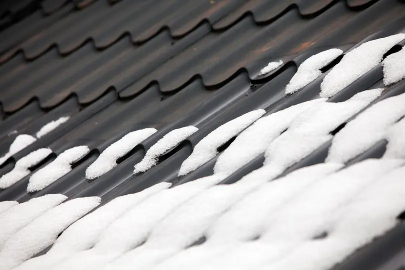 Metal roof of house with snow