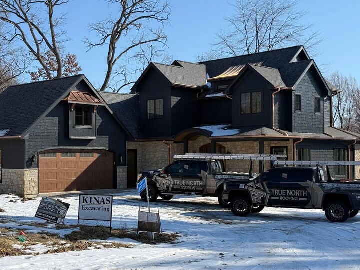 dark stone house two trucks snow